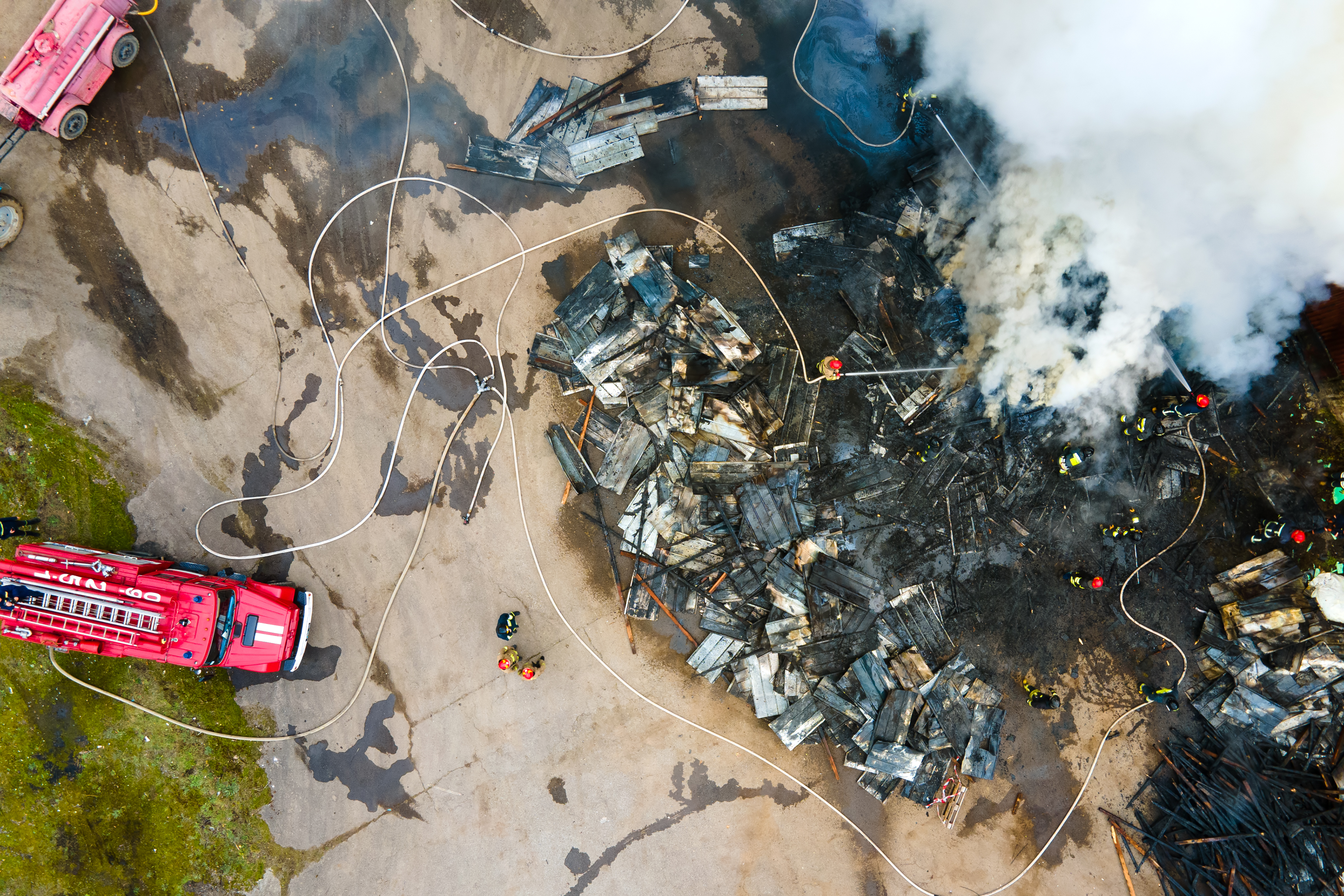 Aerial view of firemen fighting with fire near old factory biuld
